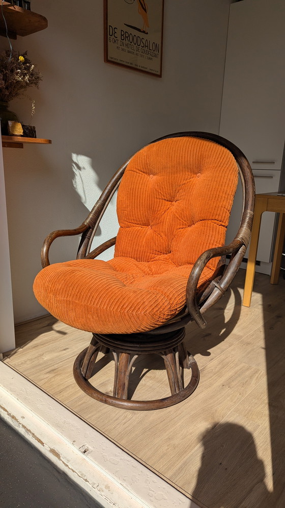 Image 1 of Draaibare rotanstoel uit de jaren 70 met oranje corduroy kussen