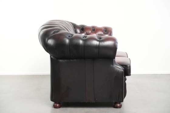 Image 1 of Canapé Chesterfield 2 places en cuir de vachette anglais ancien rouge/marron, au style magnifique et au charme intemporel.