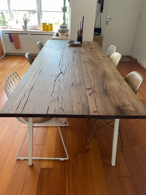 Prachtige grote eikenhouten eettafel met een wit stalen onderstel.