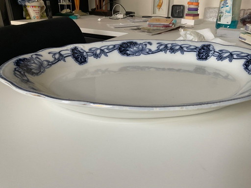 Plato de servir antiguo de porcelana con estampado azul.