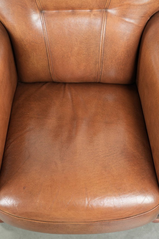 Image 1 of Fauteuil en bon état, en peau de mouton avec une finition raffinée et des clous décoratifs.