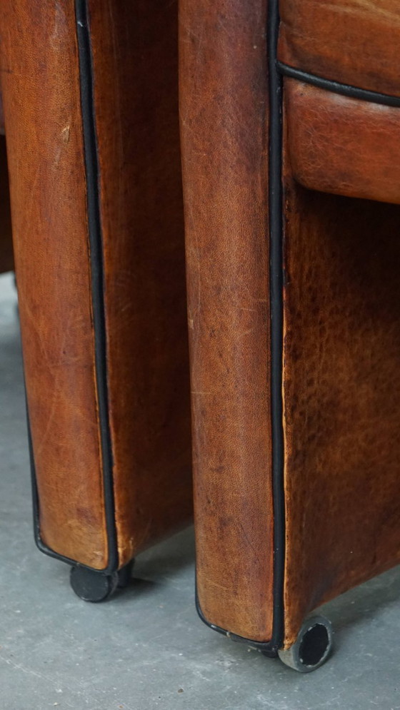 Image 1 of 4 x Vintage schapenleren eetkamerstoel met zwarte biezen op wieltjes