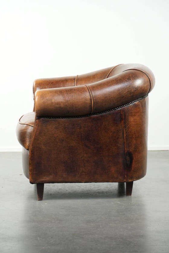 Image 1 of Karaktervolle en comfortabele clubfauteuil gemaakt van schapenleer met een vast zitkussen en uitmuntende kleuren