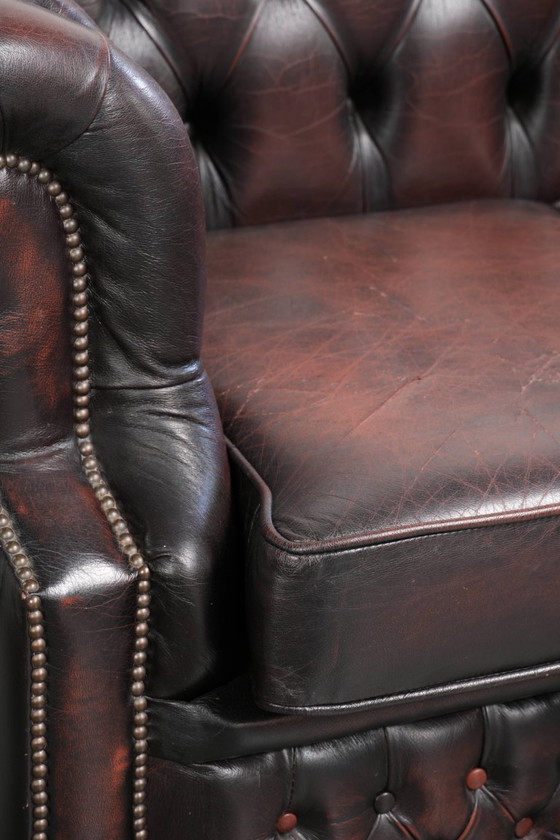 Image 1 of Canapé Chesterfield 2 places en cuir de vachette anglais ancien rouge/marron, au style magnifique et au charme intemporel.
