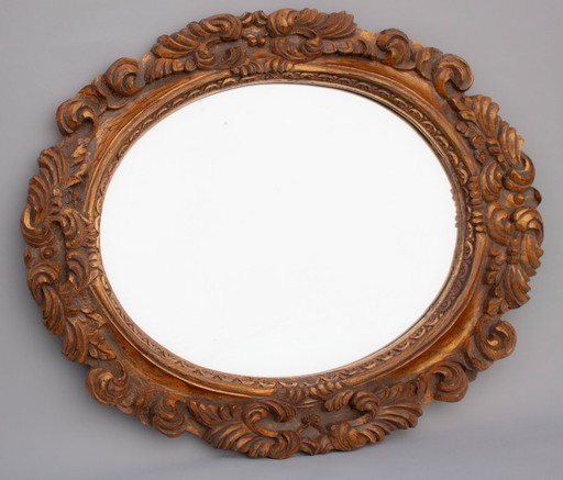 Oval mirror, gilded and carved from wood. Exclusive vintage mirror, handmade by expert artisans.