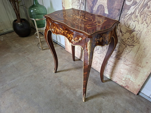 Klassieke tafel met lade gemaakt van fineer van diverse houtsoorten, voorzien van messing beslag, afm. 58x38cm en 73cm hoog.