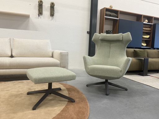 Poltrona Nosto con poggiapiedi in tessuto verde, modello disponibile a magazzino.