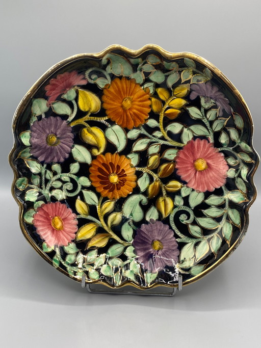 Grande piatto decorativo, in ceramica Monaco, con decorazione floreale policroma su sfondo nero. – servies, Gold