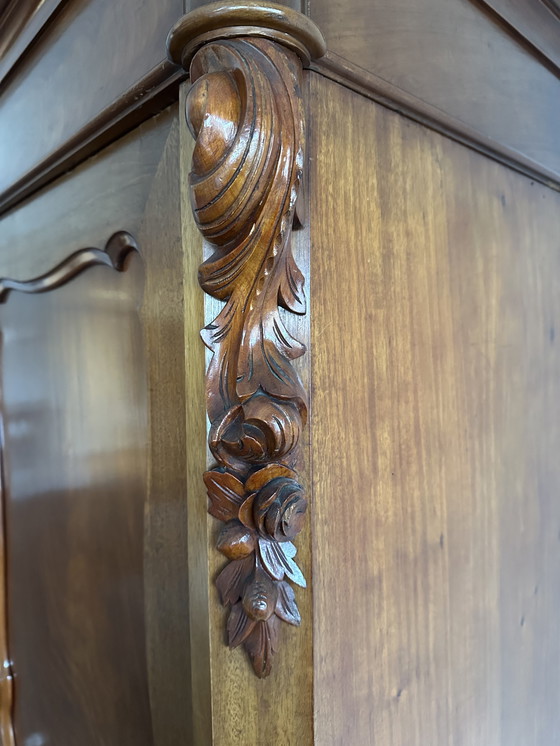 Image 1 of Armario antiguo de madera con detalles ornamentales.