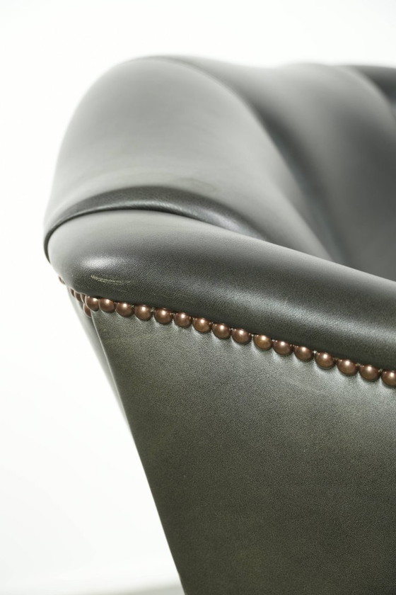 Image 1 of Zwarte rundleren oorfauteuil in een klassiek Engelse stijl
