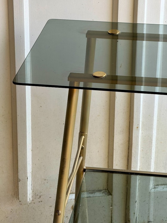 Image 1 of Carrello di servizio a due livelli in vetro fumé e metallo dorato