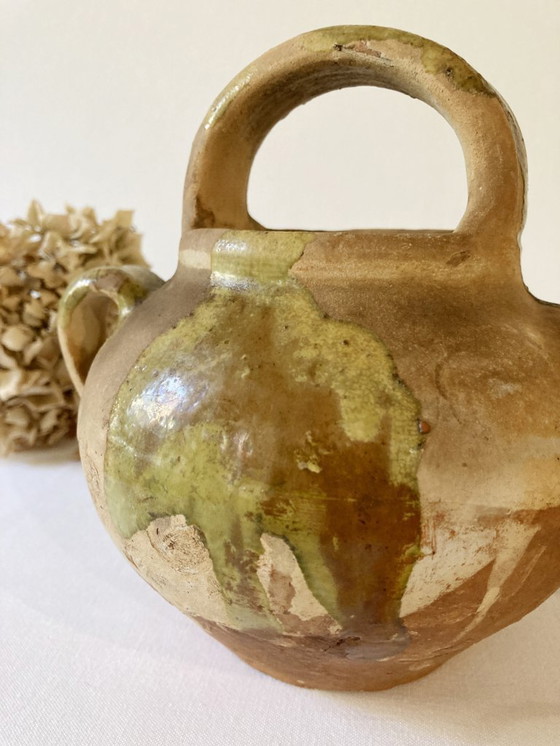 Image 1 of Klein Provençaals kannetje in de vorm van een geit, gemaakt van crèmewit en lichtgroen geglazuurd aardewerk.