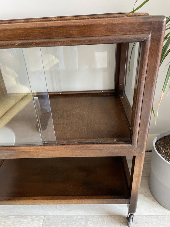 Image 1 of Eikenhouten kast uit het midden van de vorige eeuw met schuifdeuren van glas op wielen (vitrinekast / cocktailkast)