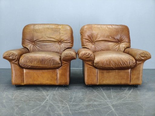 Een paar Arcon Italia loungefauteuils van cognacbruin buffelleer.