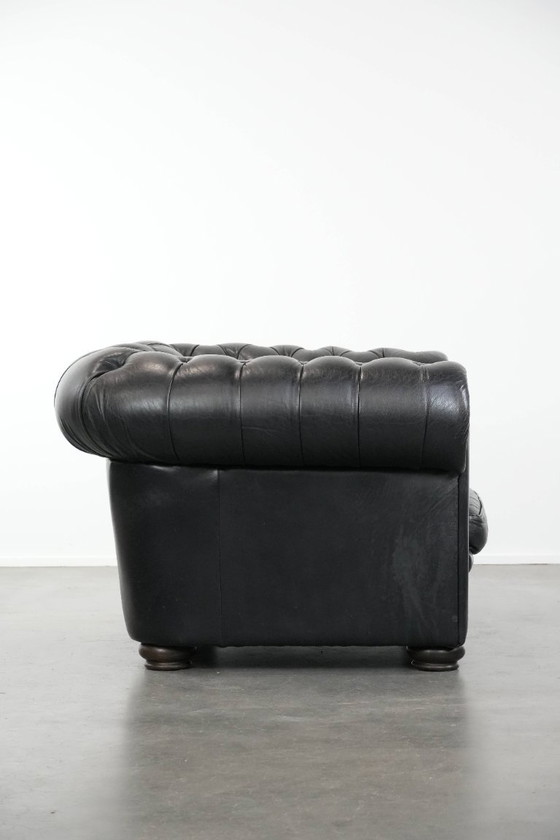 Image 1 of Set consisting of a black Chesterfield sofa, armchair and footstool made of cowhide