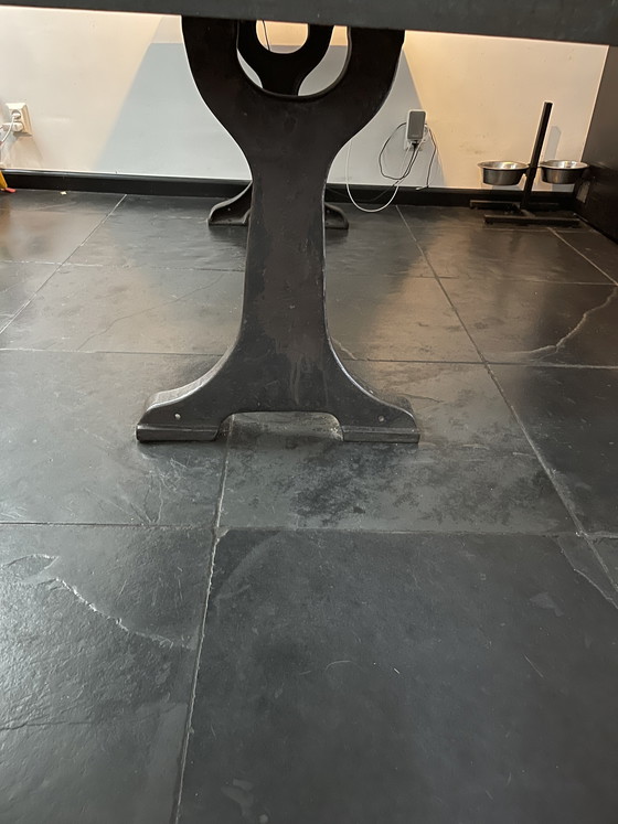 Image 1 of Industriele eettafel van oude werkbank met gietijzer onderstel y gelaste randen