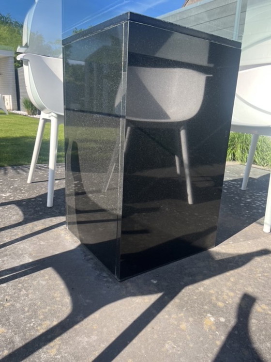 Image 1 of Tavolo da giardino quadrato di design in vetro con base a colonna in granito nero.