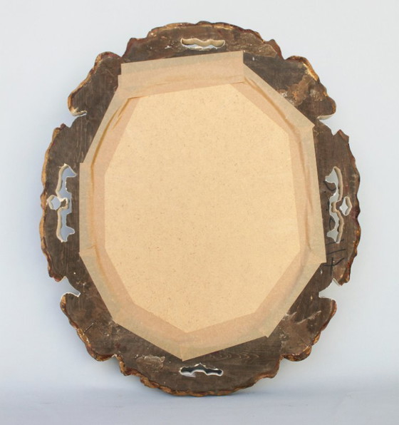 Image 1 of Oval mirror, gilded and carved from wood. Decorated and distressed with scrolls and leaves. Exclusively handmade by artisans.