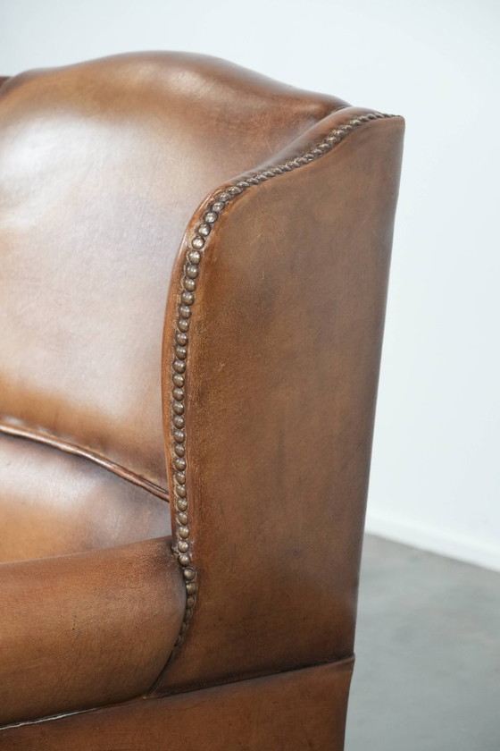 Image 1 of Sillón orejero de piel de oveja acabado con clavos decorativos