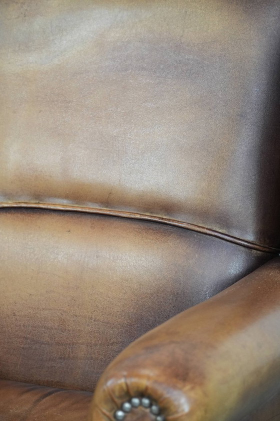 Image 1 of Sillón orejero de piel de oveja acabado con clavos decorativos