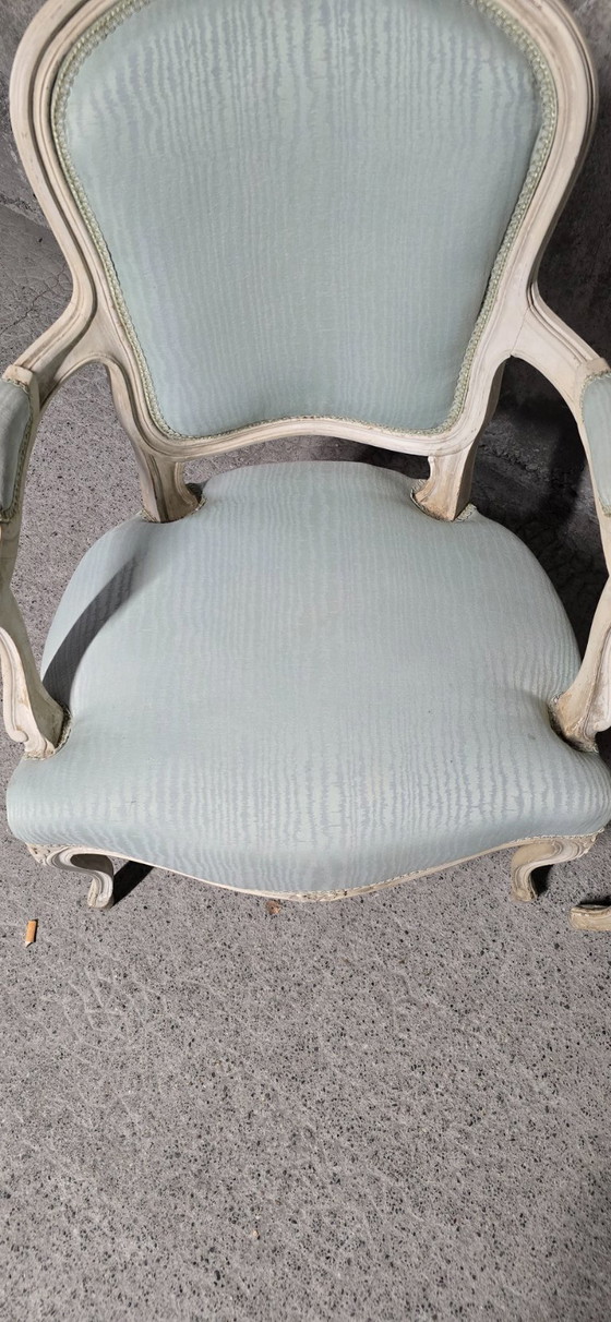 Image 1 of Coppia di poltrone in stile Luigi XV in legno patinato, con rivestimento in tessuto azzurro chiaro.