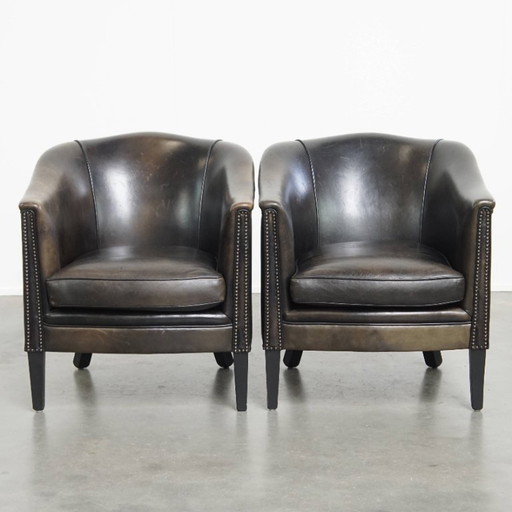  Set aus 2 dezenten schwarz/grauen Clubsesseln aus Schafsleder