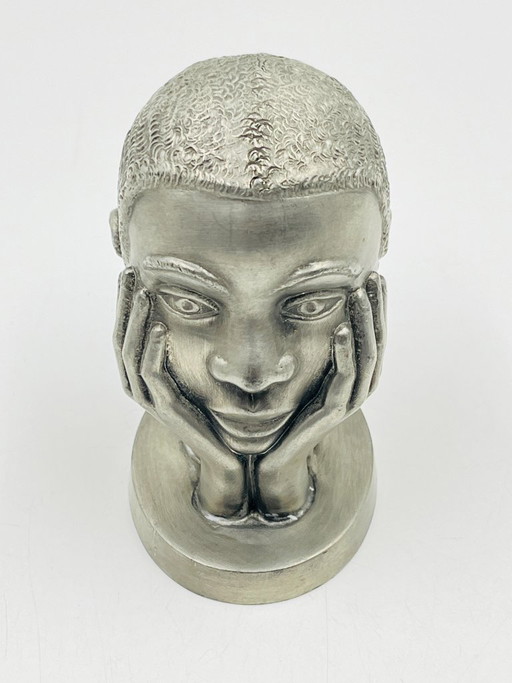 Escultura de peltre de una cabeza de mujer realizada por los trabajadores postales de Huy.