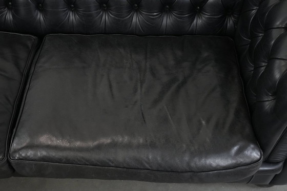 Image 1 of Set consisting of a black Chesterfield sofa, armchair and footstool made of cowhide