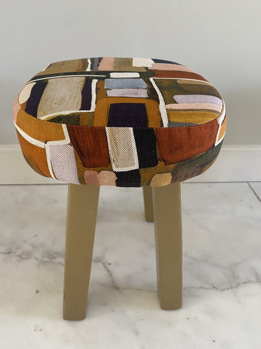 Taburete reciclado con tela de diseño.