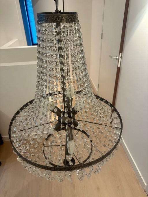 Preciosa lámpara de araña de cristal con forma de bolso y marco de bronce.
