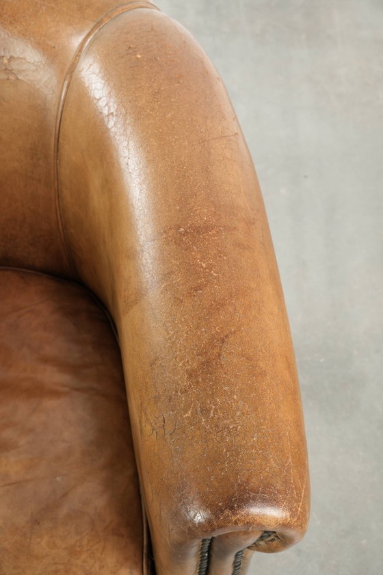 Image 1 of Vintage sheepskin club armchair with beautiful colors and finished with decorative nails.