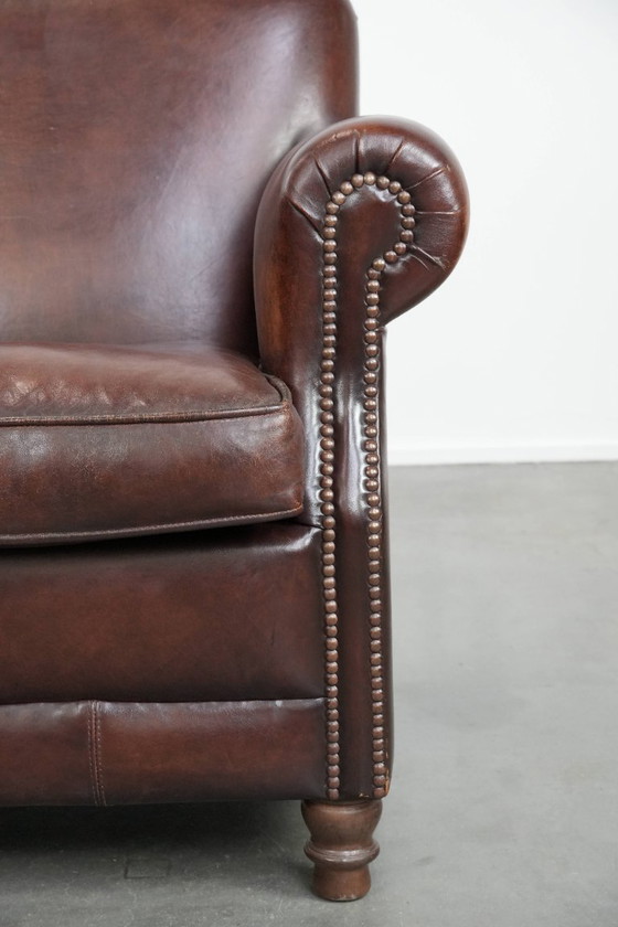 Image 1 of Fauteuil en peau de mouton aux couleurs chaudes et à la finition classique orné de clous décoratifs