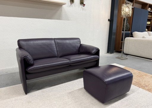 Sofá de 2 plazas Leolux Bora Bora con otomana, de piel morada.