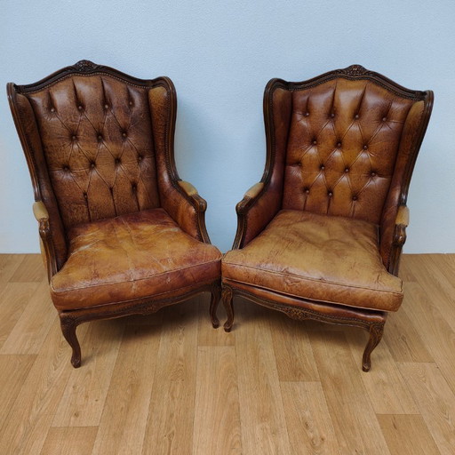 Set di poltrone vintage antiche con braccioli a forma di ala, in stile Queen Anne. Rivestite in pelle di pecora.