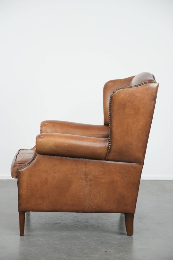 Image 1 of Sillón orejero de piel de oveja acabado con clavos decorativos