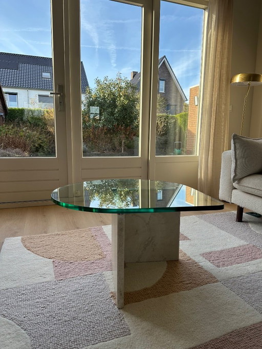 Glazen druppelvormige salontafel op travertin poot 