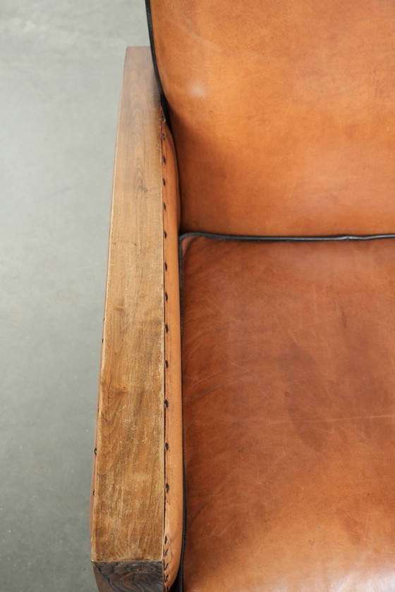 Image 1 of Schapenleren art Deco fauteuil met mooi houtsnijwerk en zwarte biezen