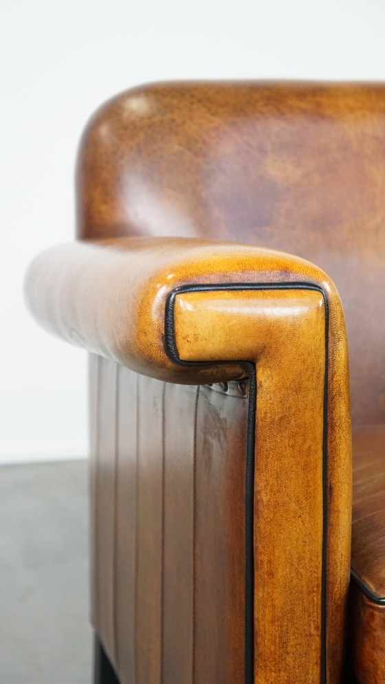 Image 1 of Sillón de diseño Art Déco en buen estado, con un acabado elegante y ribetes negros.