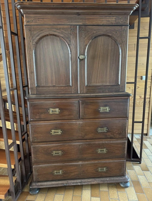 Ce meuble ancien, orné de ferrures en laiton et datant d'environ 1860-1900, présente une patine liée à son âge.