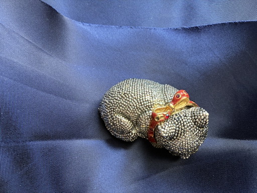 Broche représentant un petit chien avec un nœud rouge
