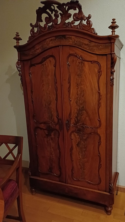 Magnifique armoire ancienne en acajou ornée d'un blason