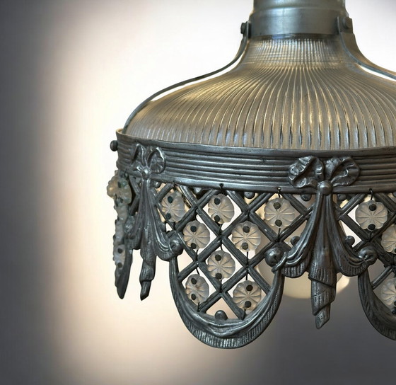 Image 1 of Dit is een antieke of vintage Holophane hanglamp met een geribbeld glazen kap en een gedetailleerde metalen rand. 