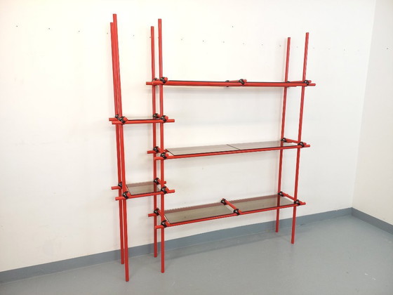 Image 1 of Vintage Italiaanse Bauhaus-boekenkast van rood metaal en rookglas uit de jaren 70.