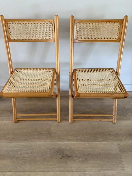 Twee vintage inklapbare houten met webbing stoelen 