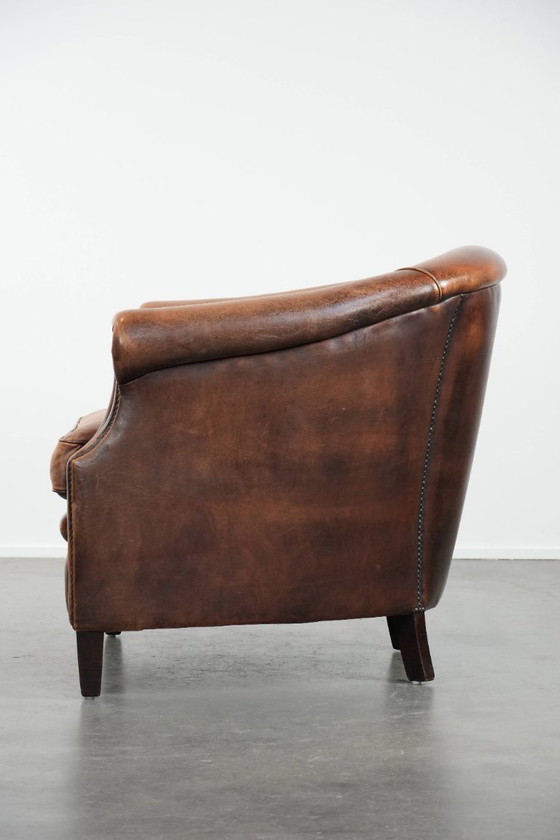 Image 1 of Clubfauteuil gemaakt van schapenleer afgewerkt met siernagels