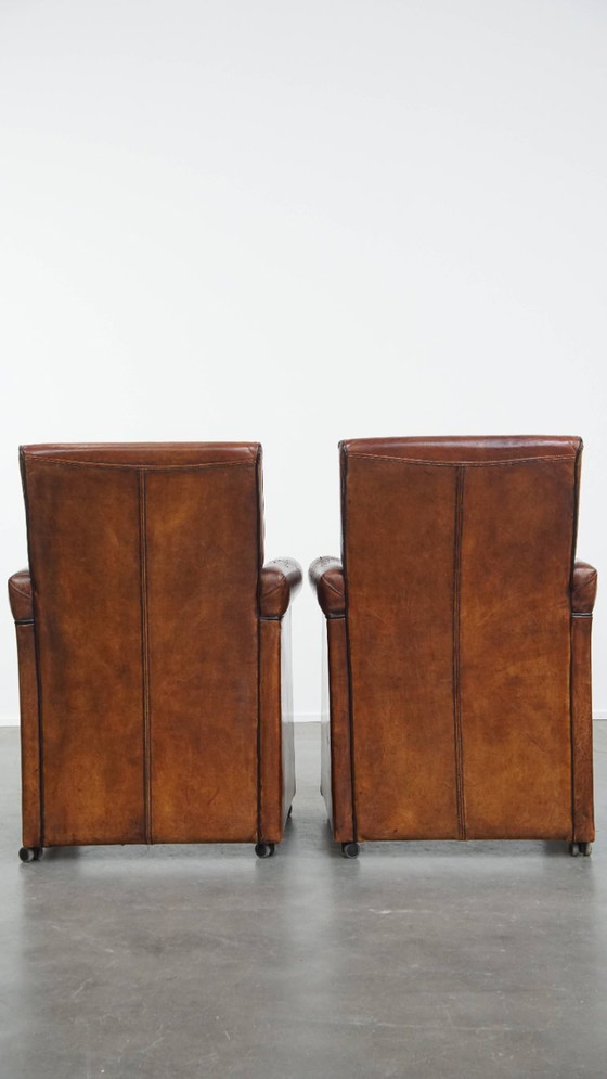 Image 1 of 6 x Vintage sheepskin dining chair with black piping on wheels