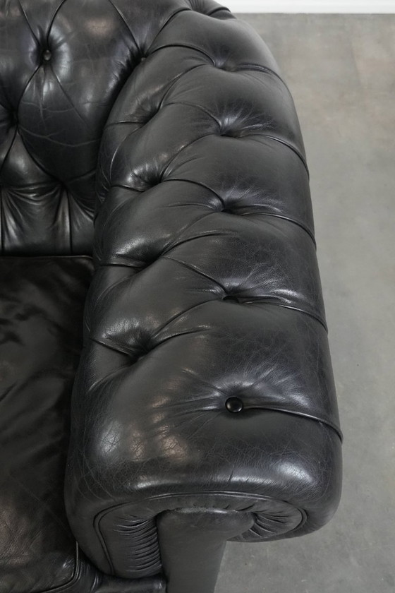 Image 1 of Set consisting of a black Chesterfield sofa, armchair and footstool made of cowhide