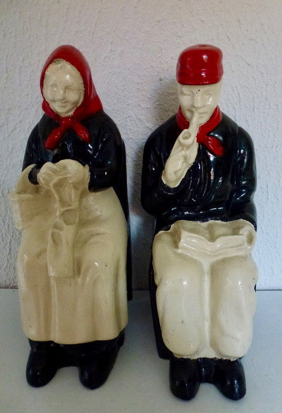 Image 1 of A set of decorative bookends depicting an elderly couple sitting on chairs.