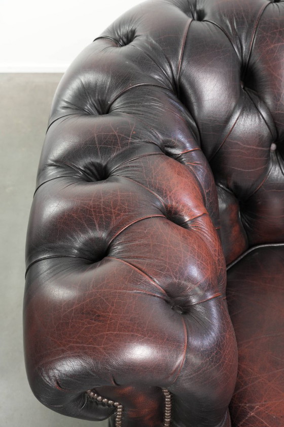 Image 1 of Canapé Chesterfield 2 places en cuir de vachette anglais ancien rouge/marron, au style magnifique et au charme intemporel.
