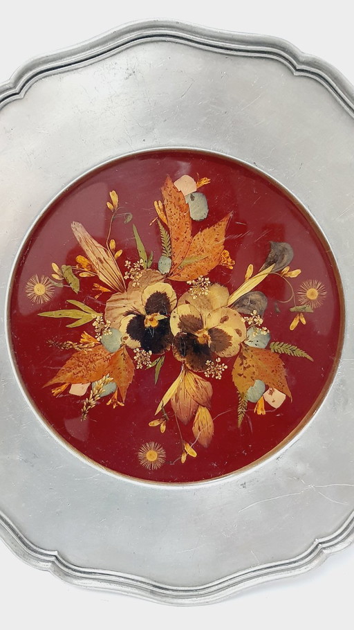 Vintage pewter wall hanging plate with a pressed or dried floral arrangement set in resin